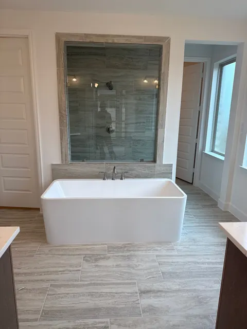 Bathroom with a freestanding tub and a tiled glass shower