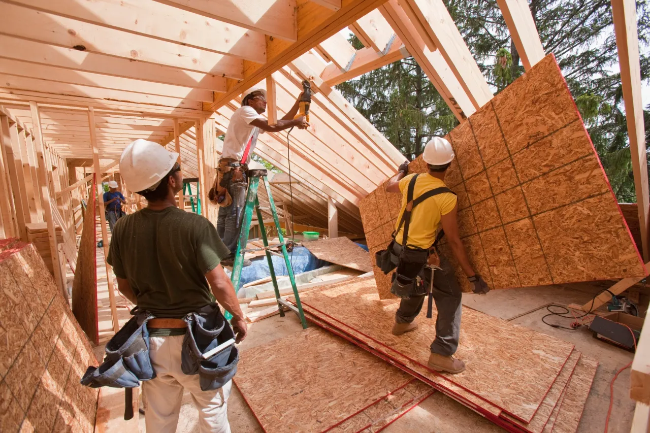 Workers assembling timber framing and wall sheathing