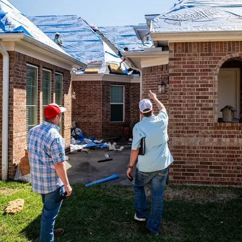 Two Down South team members checking a roof covered in new underlayment