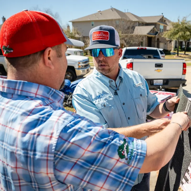 Down South team members comparing shingle samples in a driveway