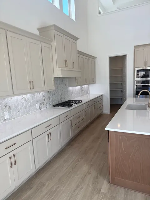 Kitchen with shaker cabinets, a herringbone backsplash and a gas cooktop