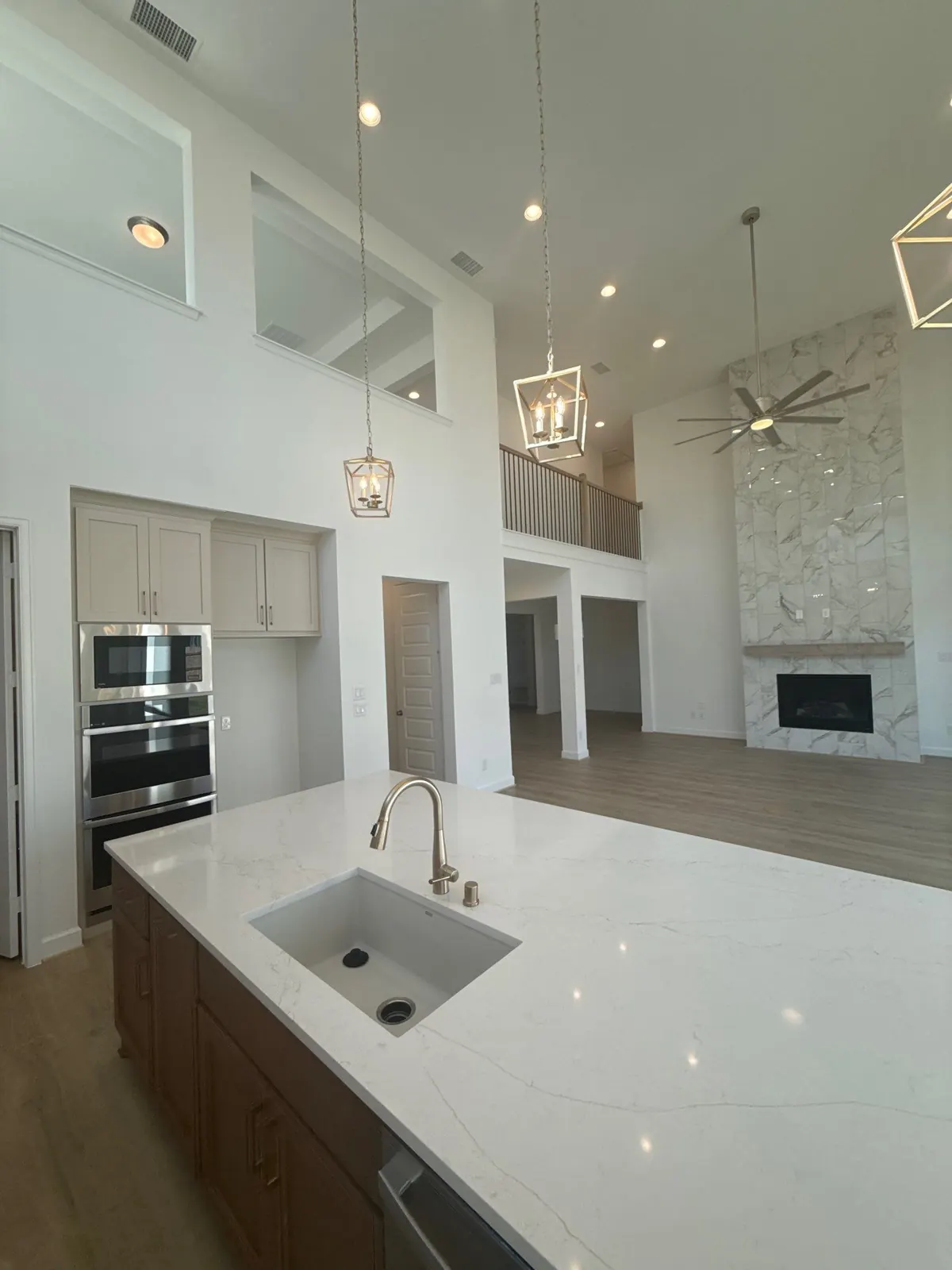 Kitchen with a quartz island and brass pendant lighting