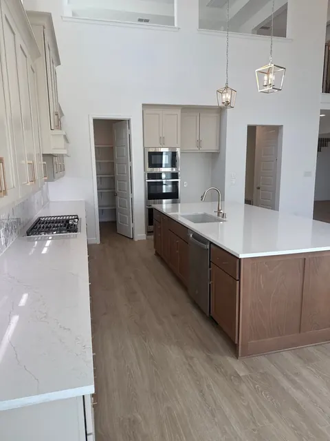 Kitchen with double wall ovens and long quartz counters